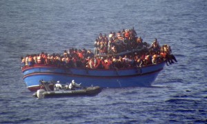Picture from the Guardian website: A motor boat from the Italian frigate Grecale approaches a boat overcrowded with migrants in the Mediterranean. Photograph: Italian Navy/AP